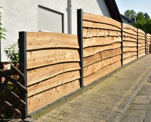 Natürlicher Gartensichtschutz aus einem Holzplanken-Zaun